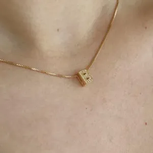 COLAR DE LETRA M CRAVEJADA PASSANTE. 45CM DE COMPRIMENTO. BANHADO A OURO 18K.
