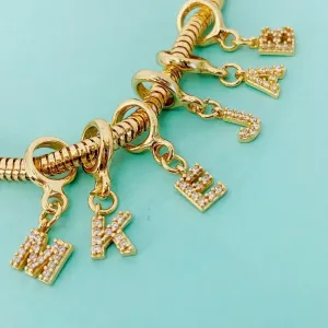 BERLOQUE DE LETRA K CRAVEJADO. BANHADO A OURO 18K.