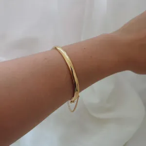 PULSEIRA BRACELETE RÍGIDO 5MM COM CORRENTE DE SEGURANÇA. 6,5CM DE DIÂMETRO INTERNO. BANHADA A OURO 18K.