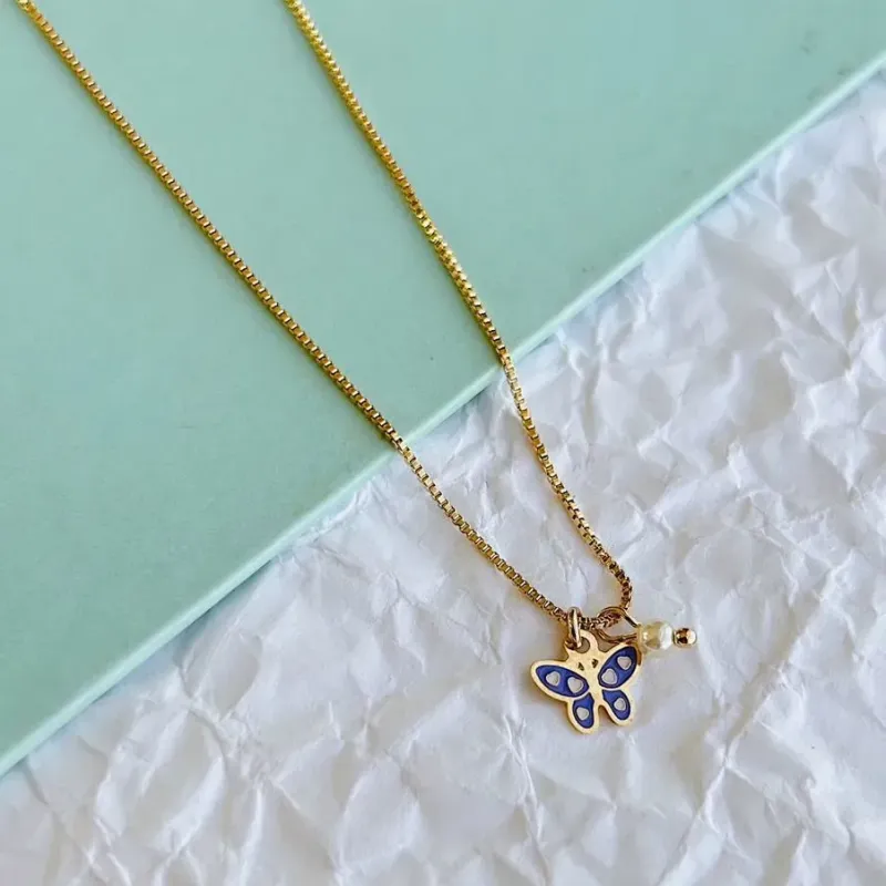 COLAR INFANTIL BORBOLETA ROXA E PÉROLA. 35CM  DE COMPRIMENTO COM 3,5CM DE REGULAGEM. BANHADO A OURO 18K.