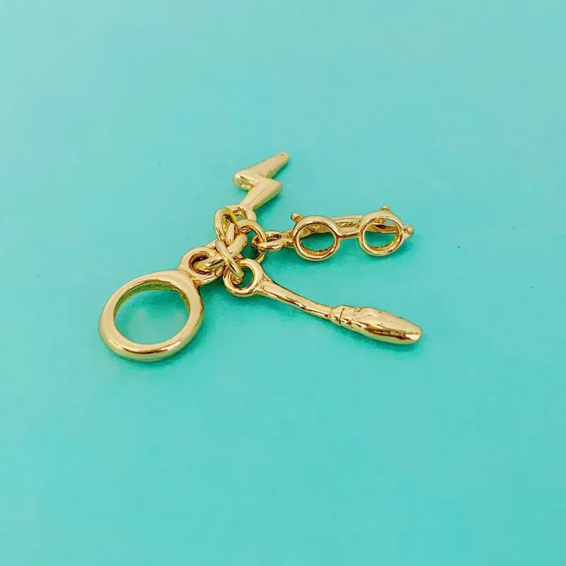 BERLOQUE SÍMBOLOS HARRY POTTER. BANHADO A OURO 18K.