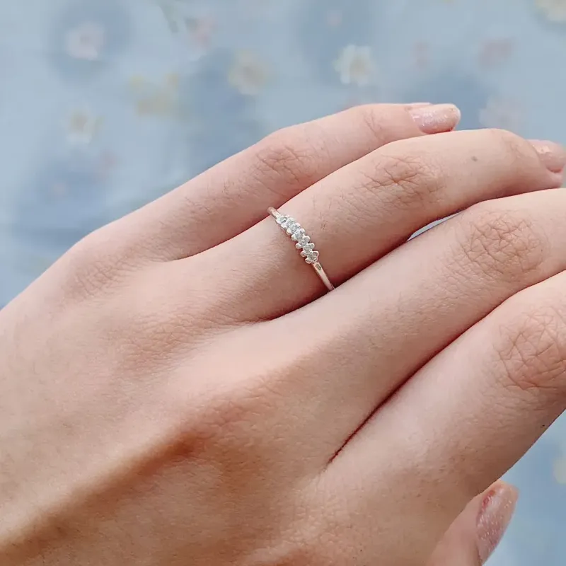 ANEL COM DETALHE DE 7 ZIRCÔNIAS. EM PRATA 925.