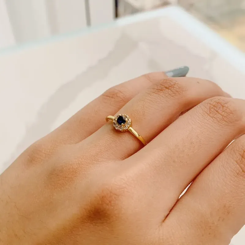 ANEL PEDRA AZUL COM BORDA CRAVEJADA. BANHADO A OURO 18K.