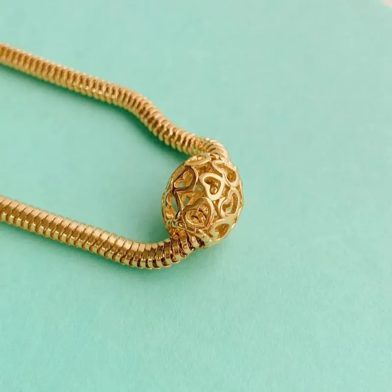 BERLOQUE SEPARADOR OVAL CORAÇÕES VAZADOS. BANHADO A OURO 18K.