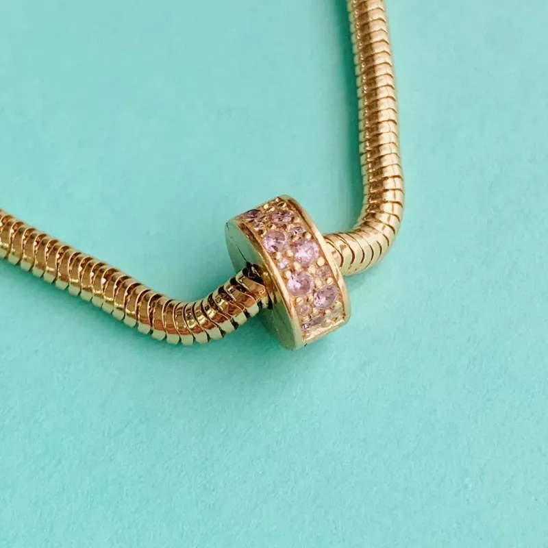 BERLOQUE TRAVA CRAVEJADA ROSA. BANHADO A OURO 18K.