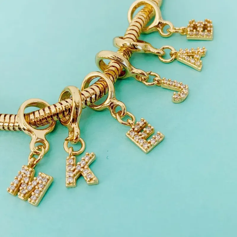 BERLOQUE DE LETRA I CRAVEJADO. BANHADO A OURO 18K.