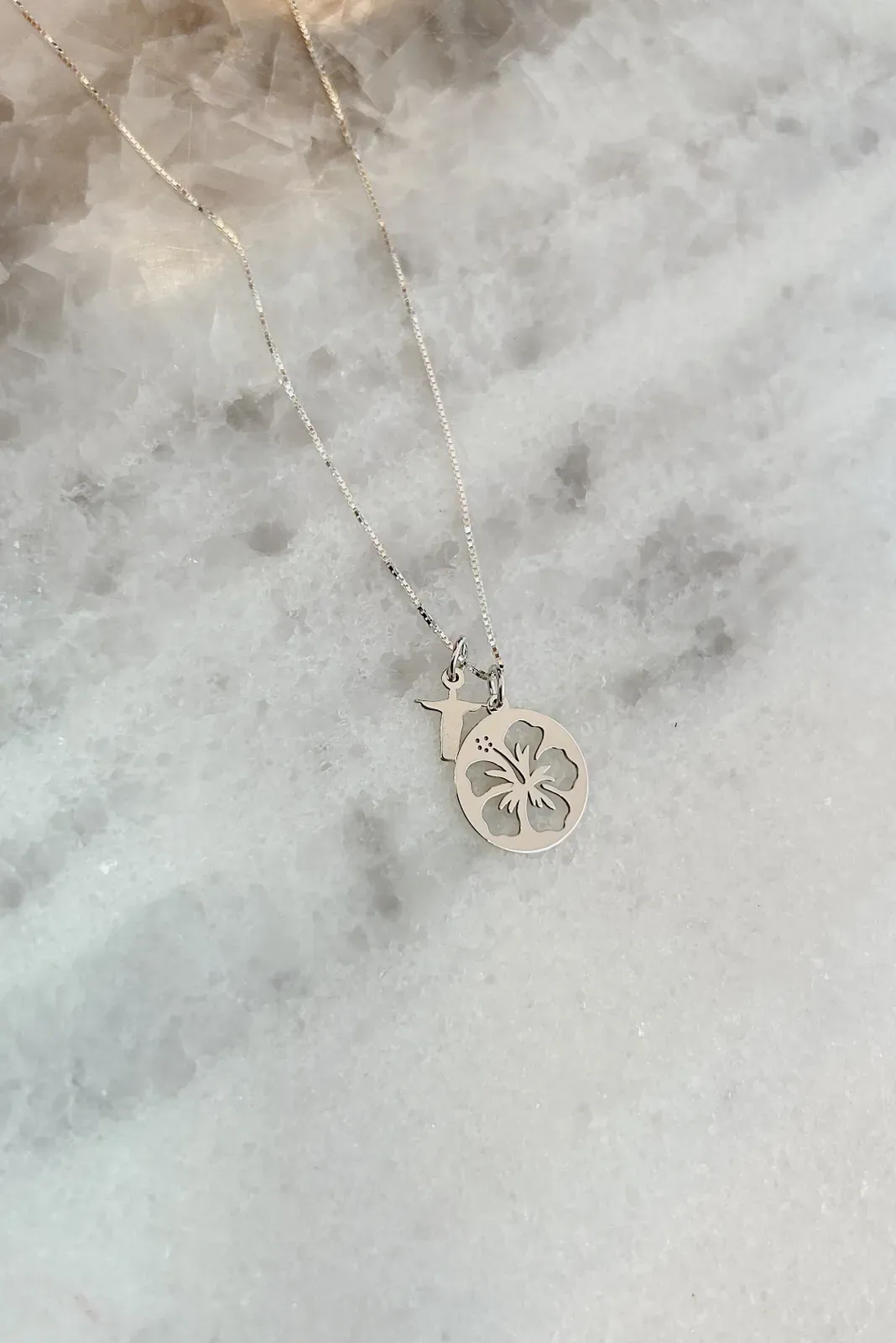COLAR COM MEDALHA DE FLOR DE HIBISCO VAZADA E MINI CRISTO REDENTOR EM PRATA 925.