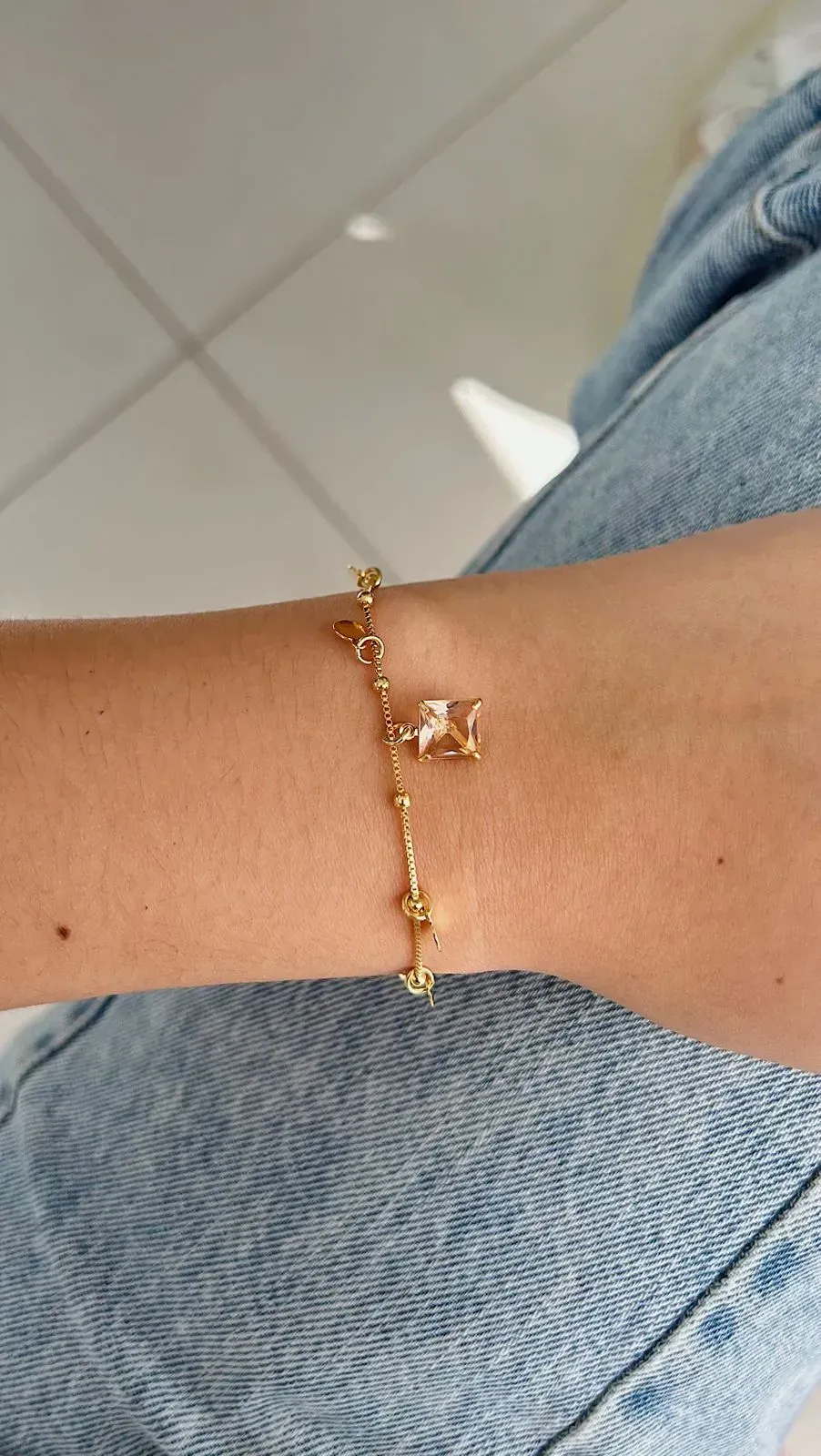 PULSEIRA BOLINHAS COM PEDRA CHAMPANHE QUADRADA E MEDALINHAS. 18CM DE COMPRIMENTO COM 4CM DE REGULAGEM. BANHADA A OURO 18K.