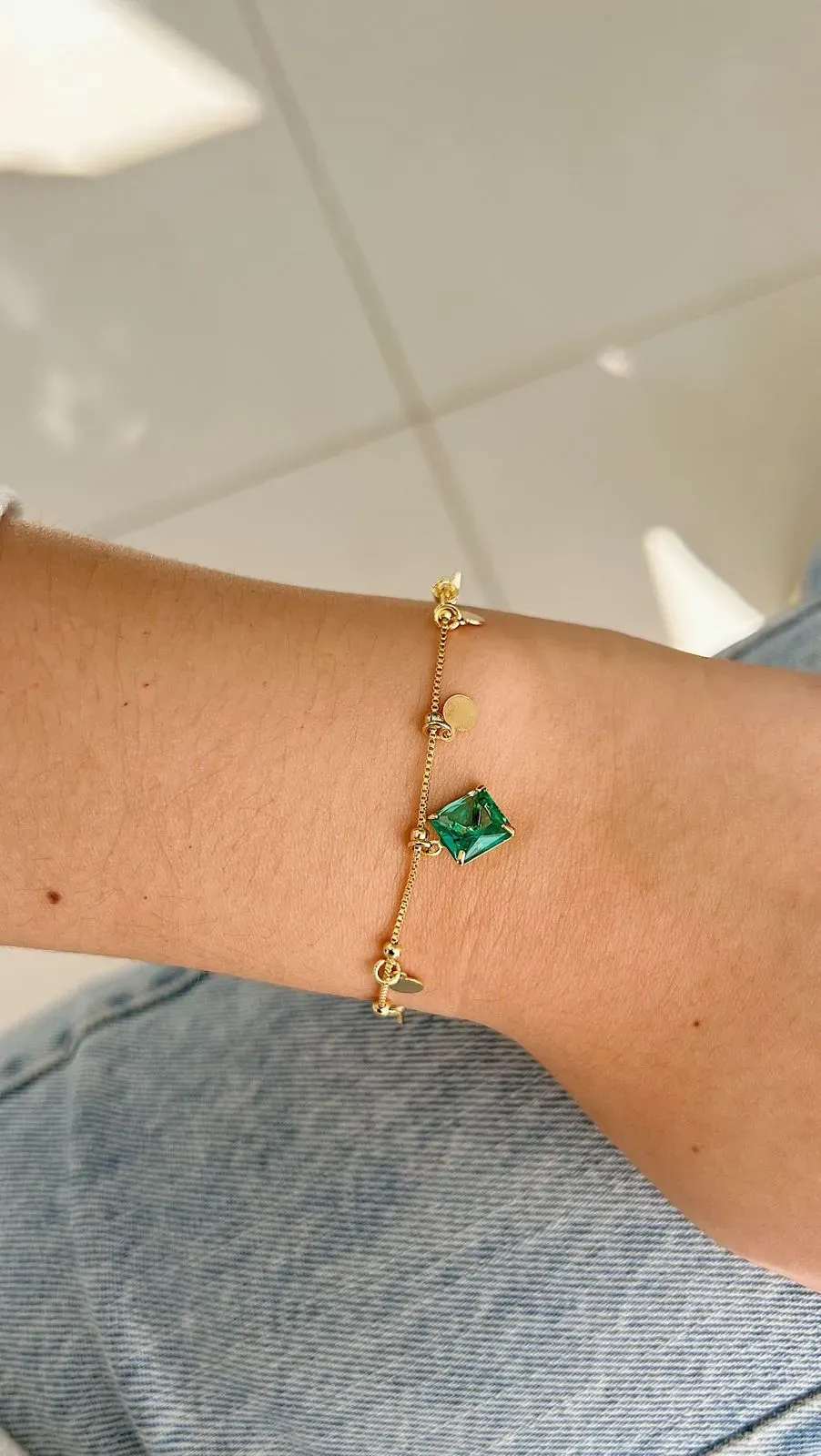 PULSEIRA BOLINHAS COM PEDRA VERDE QUADRADA E MEDALINHAS. 18CM DE COMPRIMENTO COM 4CM DE REGULAGEM. BANHADA A OURO 18K.
