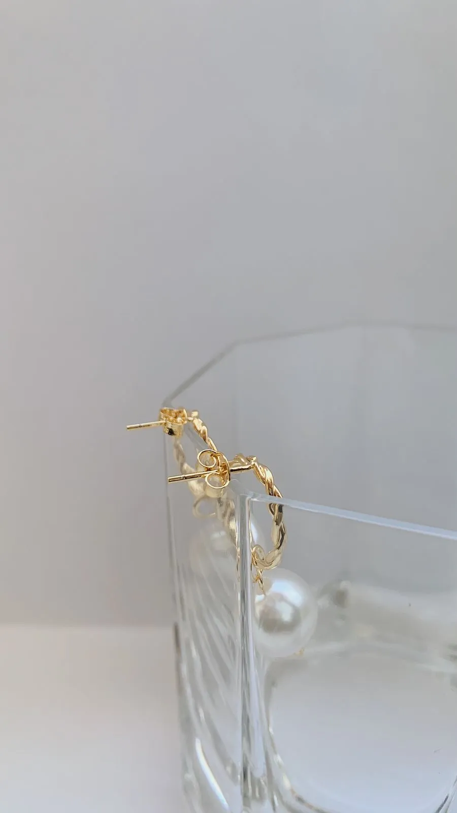 BRINCO CÍRCULO TORCIDO COM PÉROLA. BANHADO A OURO 18K.