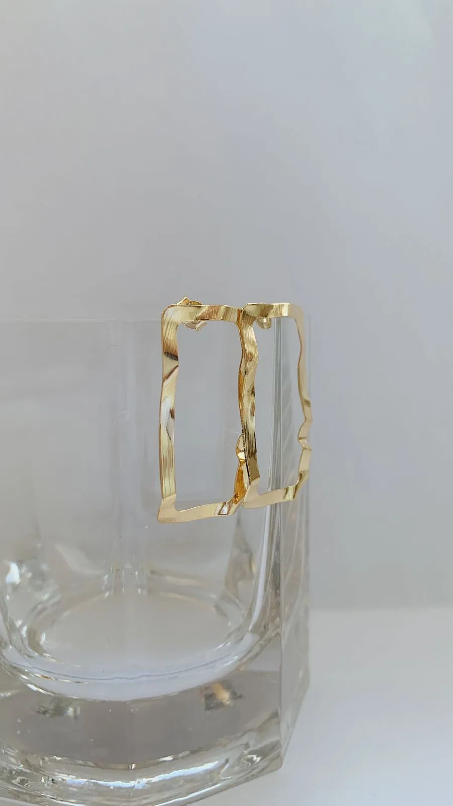 BRINCO RETÂNGULO MARTELADO. BANHADO A OURO 18K.