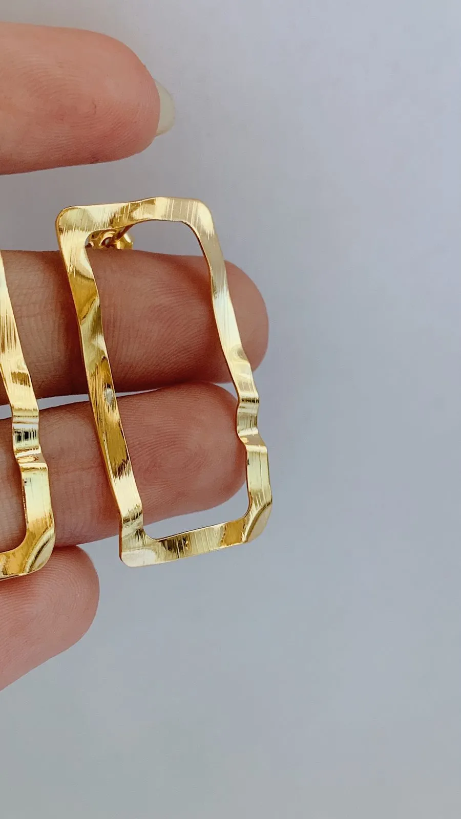 BRINCO RETÂNGULO MARTELADO. BANHADO A OURO 18K.