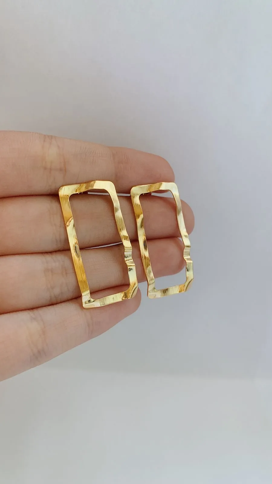 BRINCO RETÂNGULO MARTELADO. BANHADO A OURO 18K.