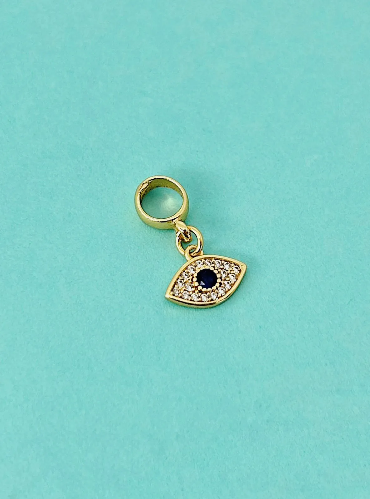BERLOQUE OLHO GREGO CRAVEJADO. BANHADO A OURO 18K.