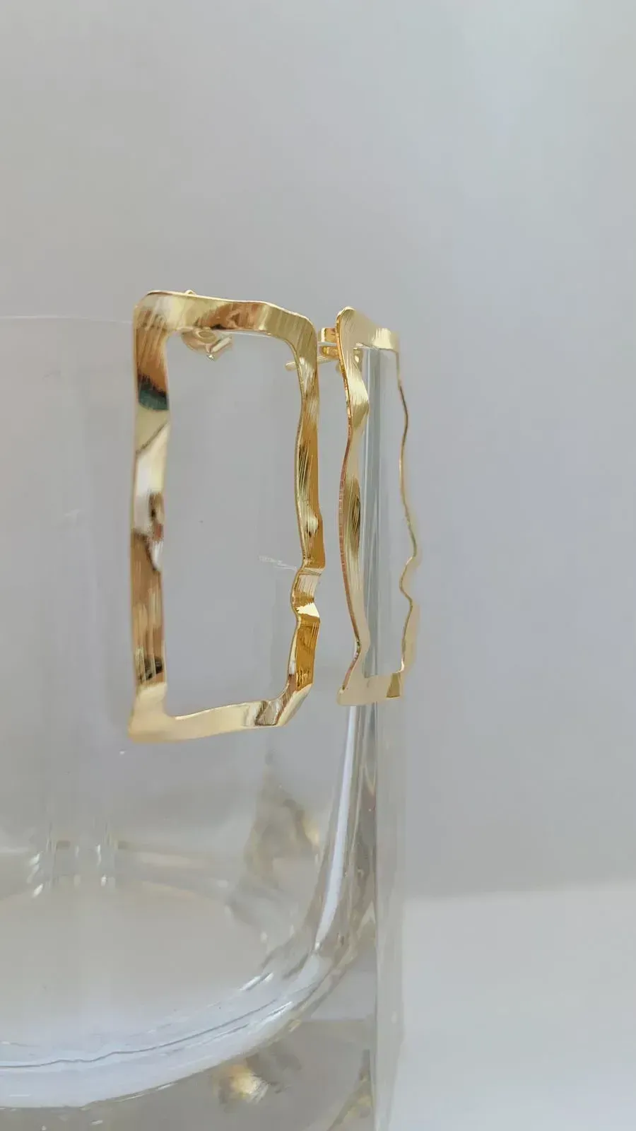 BRINCO RETÂNGULO MARTELADO. BANHADO A OURO 18K.