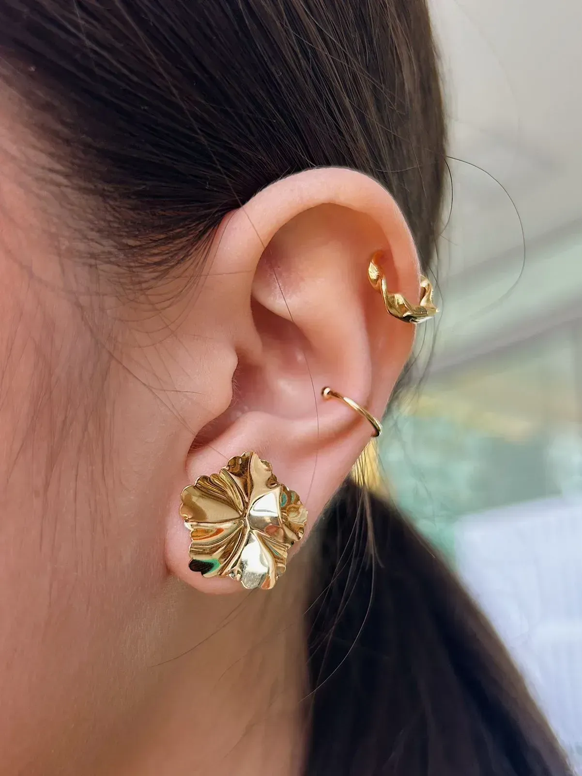 BRINCO FLOR MARTELADA. BANHADO A OURO 18K.