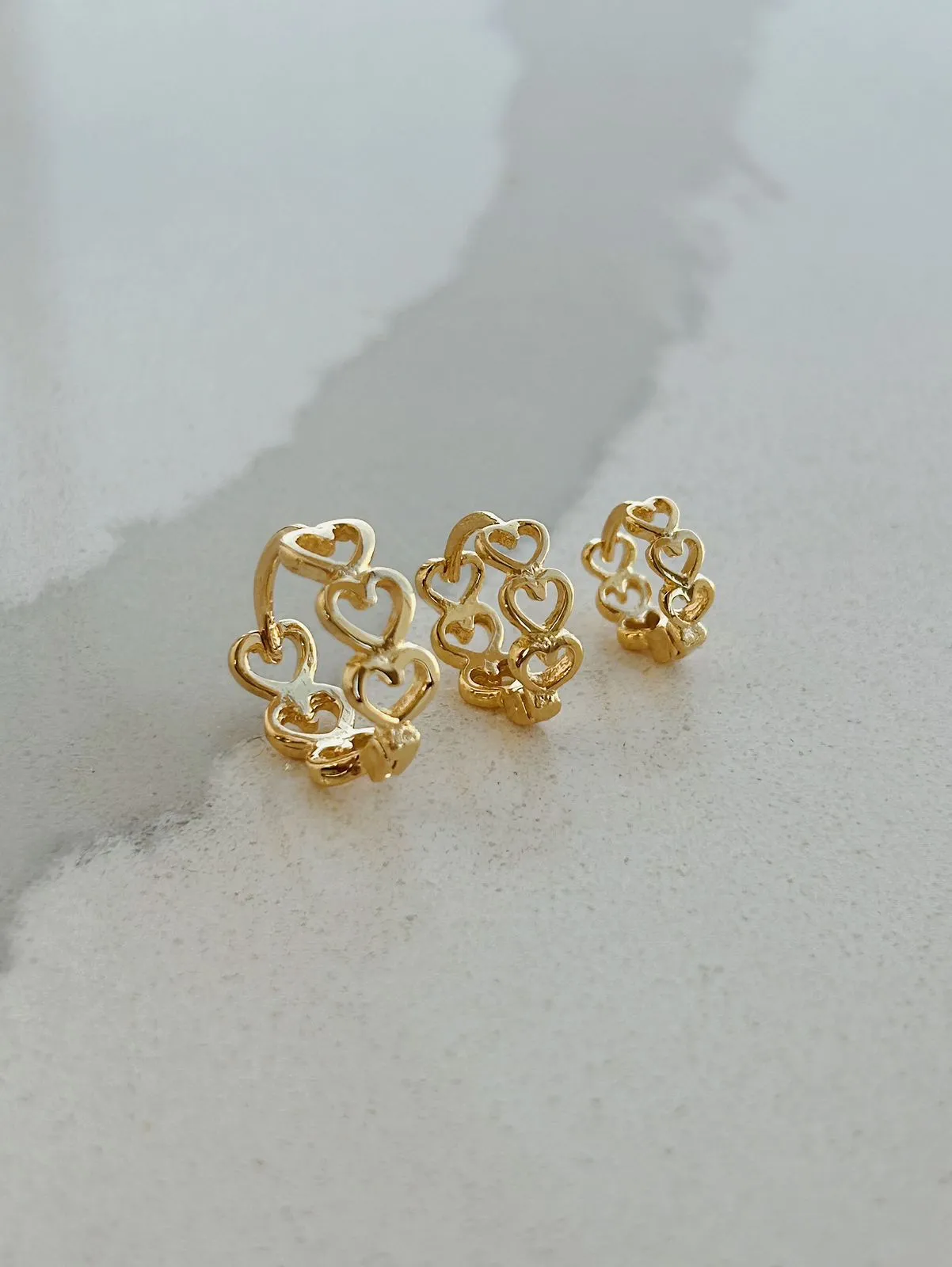 BRINCO ARGOLA COM CORAÇÕES VAZADOS. TAMANHO P. BANHADO A OURO 18K.