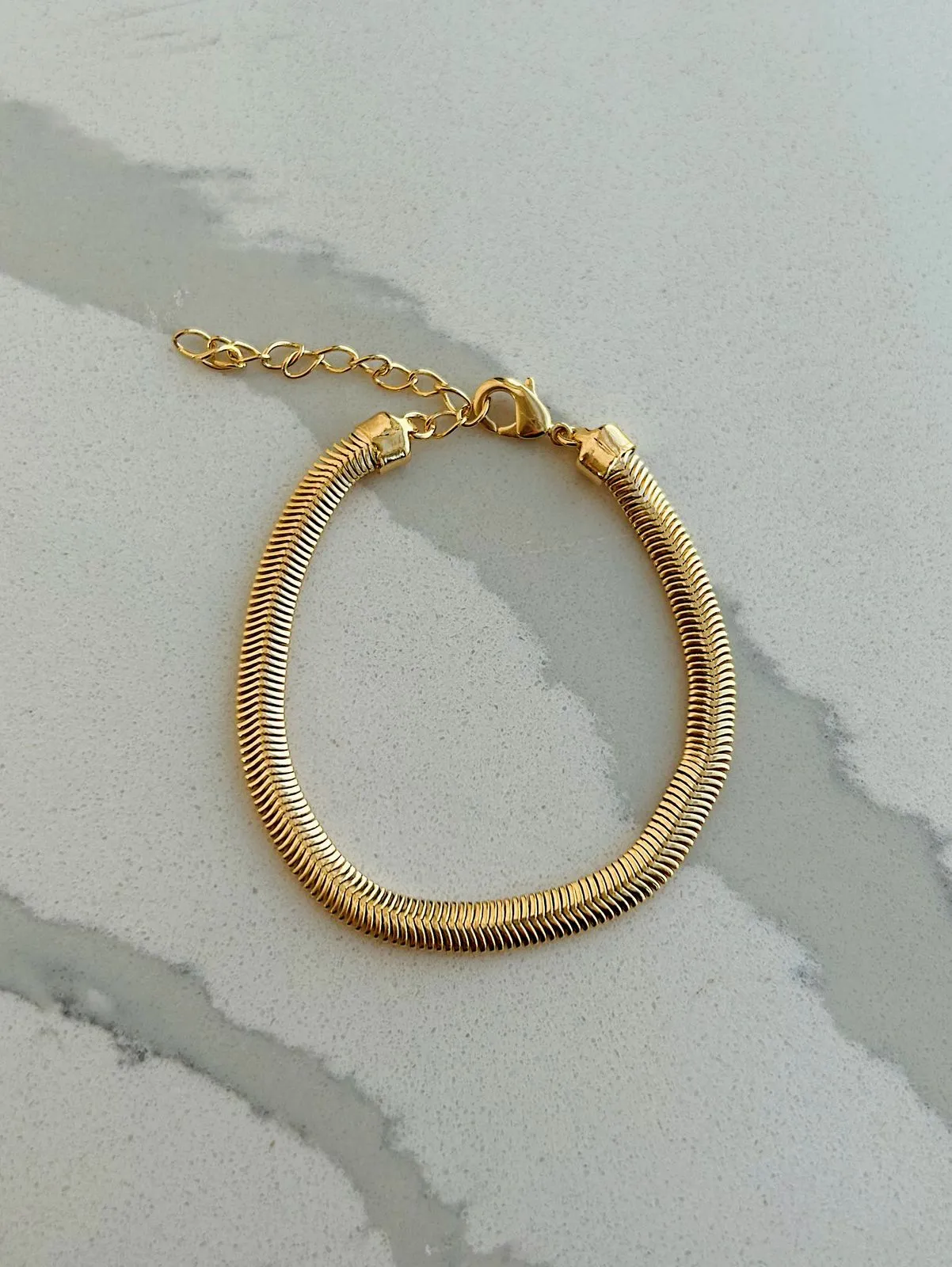 PULSEIRA SNAKE COM 5MM DE ESPESSURA. 16CM DE COMPRIMENTO E 4,5CM DE REGULAGEM. BANHADA A OURO 18K.