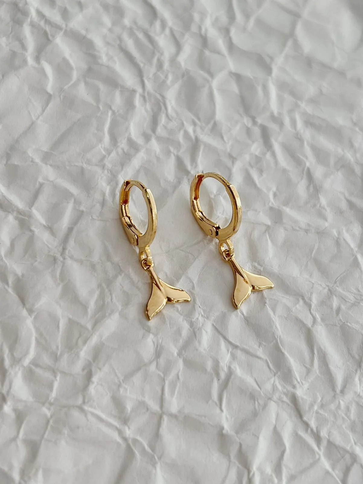 BRINCO ARGOLA COM PINGENTE DE CAUDA DE SEREIA. BANHADO A OURO 18K.