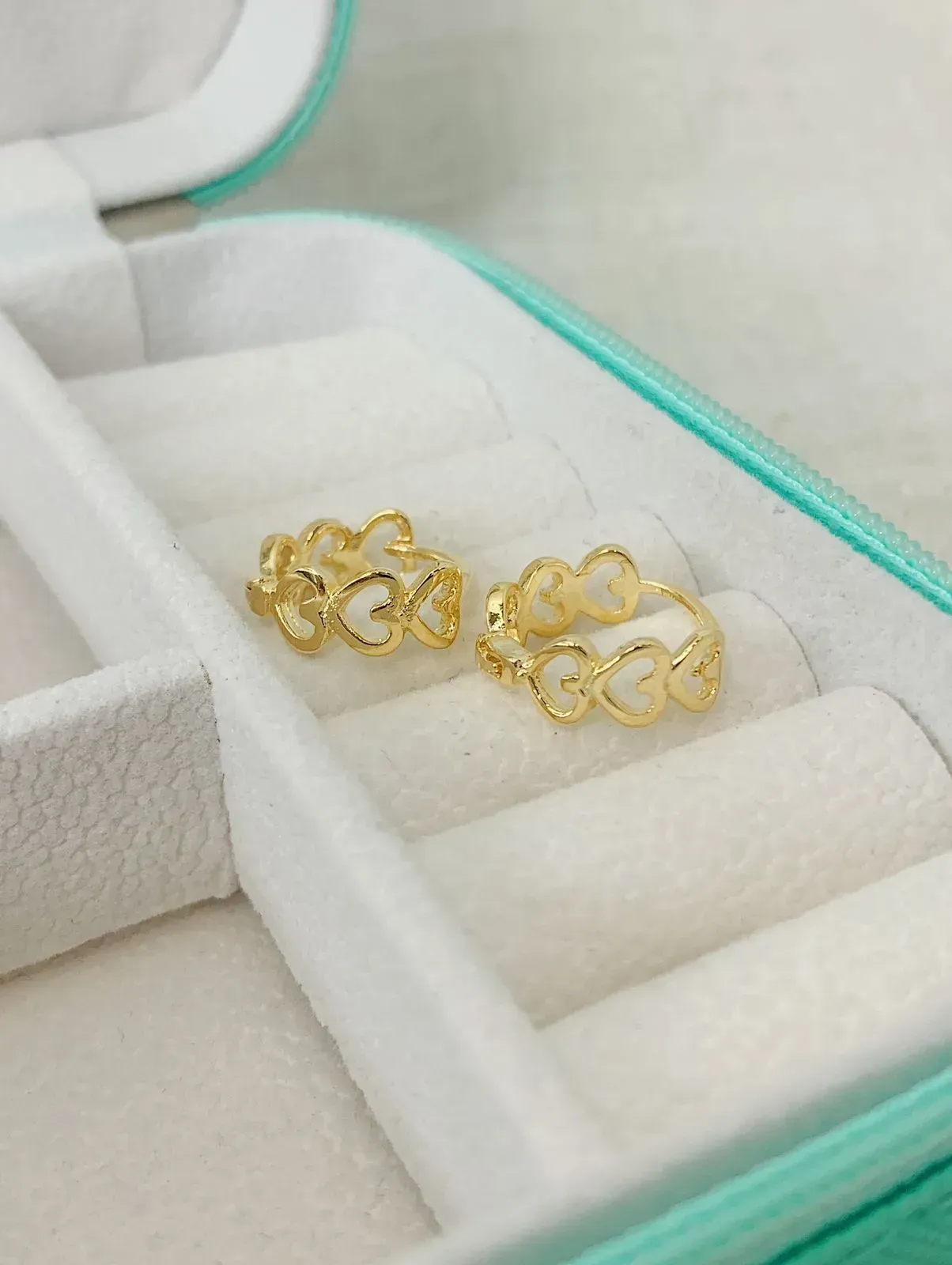 BRINCO ARGOLA COM CORAÇÕES VAZADOS. TAMANHO G. BANHADO A OURO 18K.