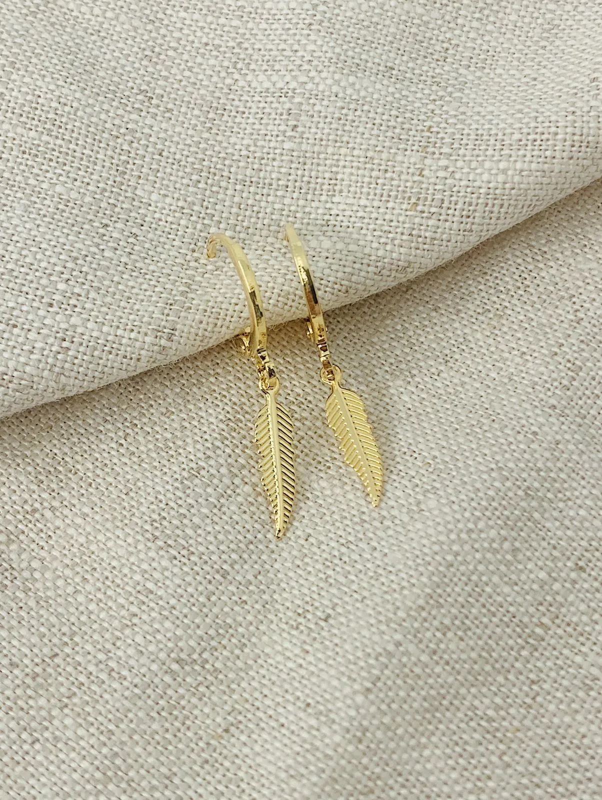 BRINCO ARGOLA COM PINGENTE DE FOLHA. BANHADO A OURO 18K.