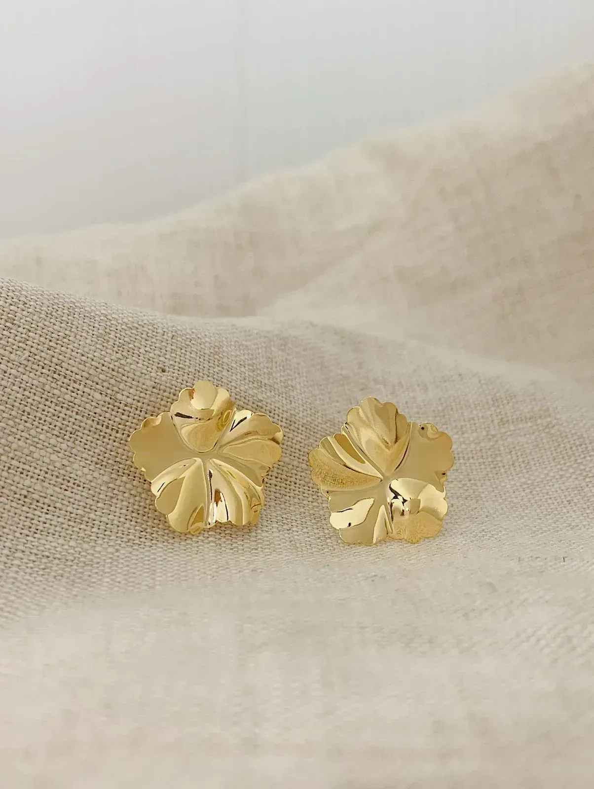 BRINCO FLOR MARTELADA. BANHADO A OURO 18K.
