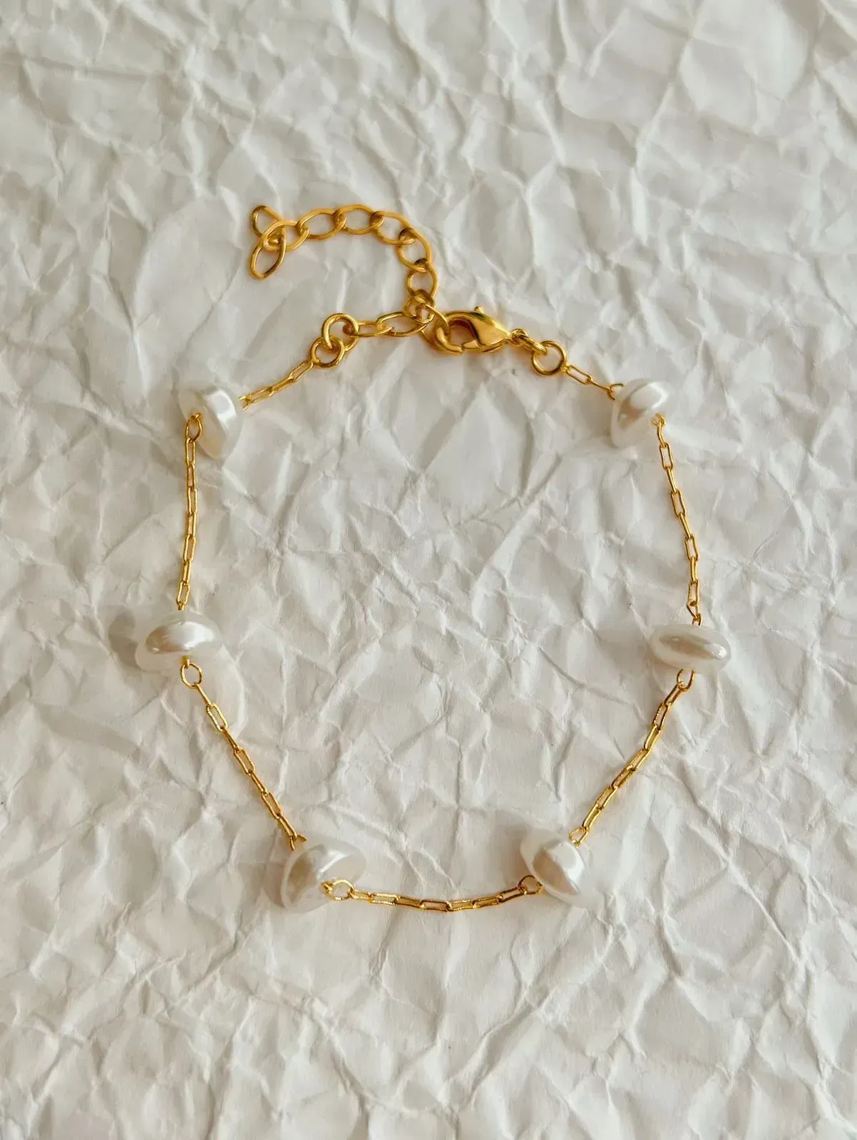 PULSEIRA DE PÉROLA BARROCA. 17CM DE COMPRIMENTO E 5 CM DE REGULAGEM. BANHADA A OURO 18K.