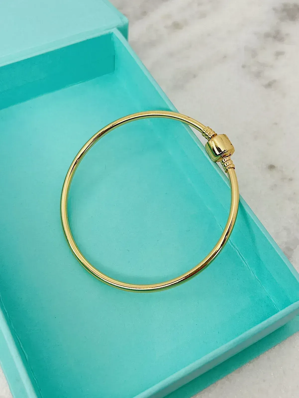 PULSEIRA MOMENTOS DOURADA RÍGIDA. 6CM DE DIÂMETRO. BANHADA A OURO 18K.