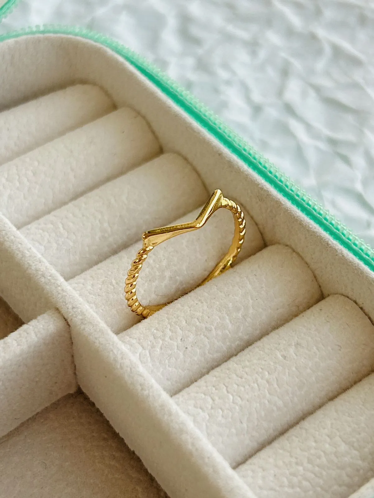 ANEL V COM MEIO ARO TORCIDO. BANHADO A OURO 18K.