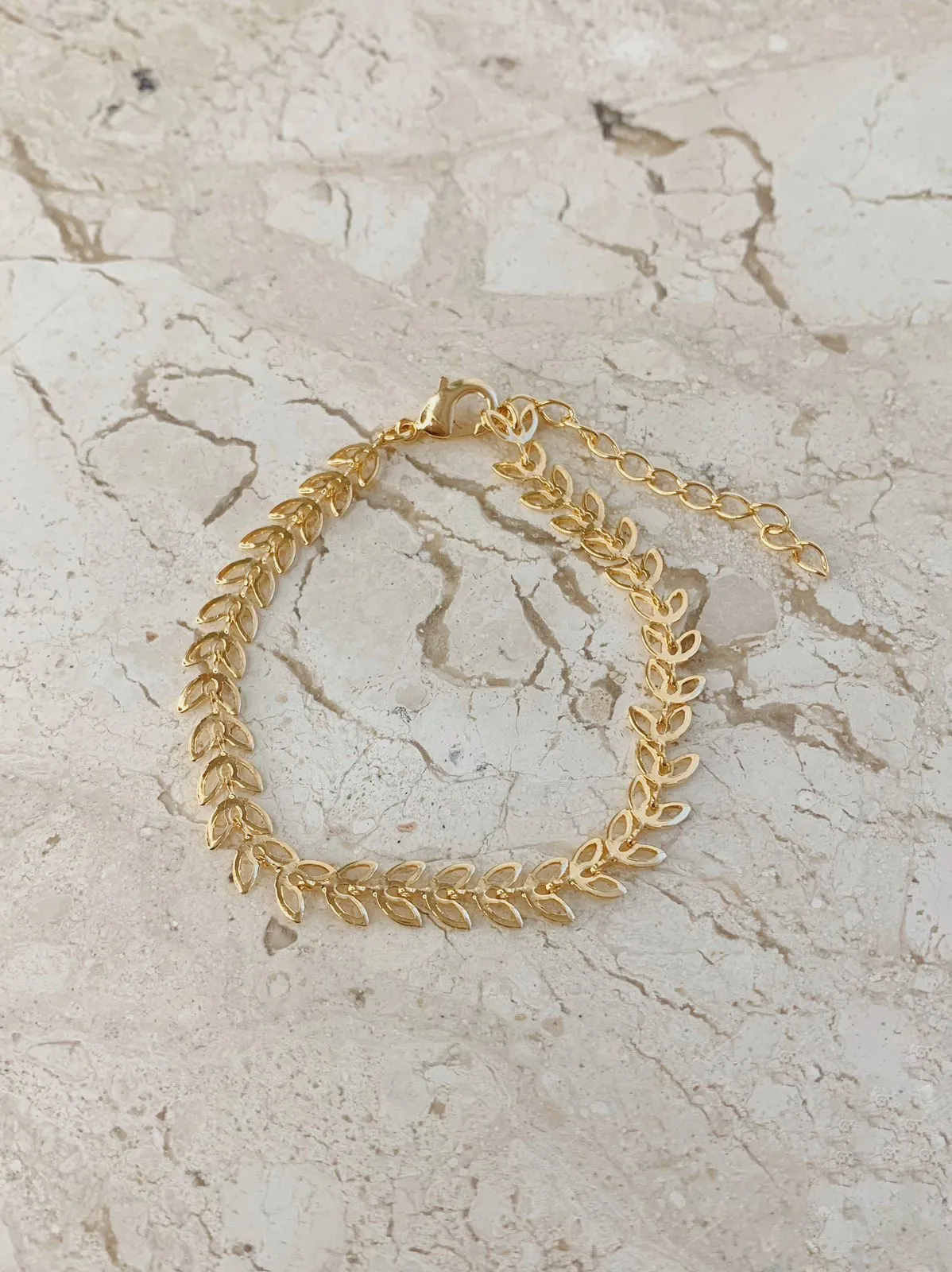 PULSEIRA FOLHINHAS VAZADAS.16CM DE COMPRIMENTO E 5CM DE REGULAGEM. BANHADA A OURO 18K.