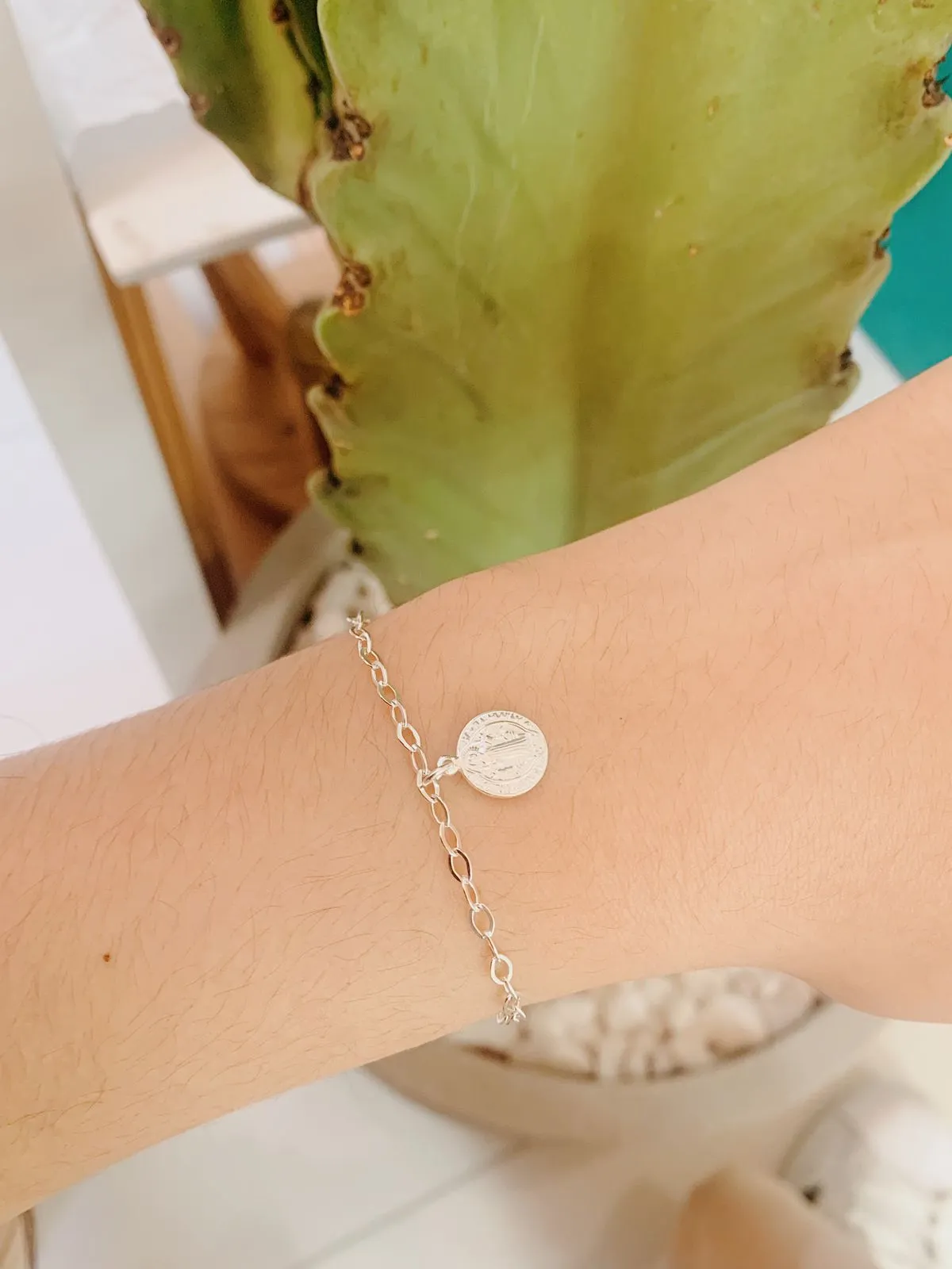 PULSEIRA ELOS COM PINGENTE DE MEDALHA DE SÃO BENTO COM 1CM DE DIÂMETRO. 17,5CM DE COMPRIMENTO E 1CM DE REGULAGEM. EM PRATA 925.