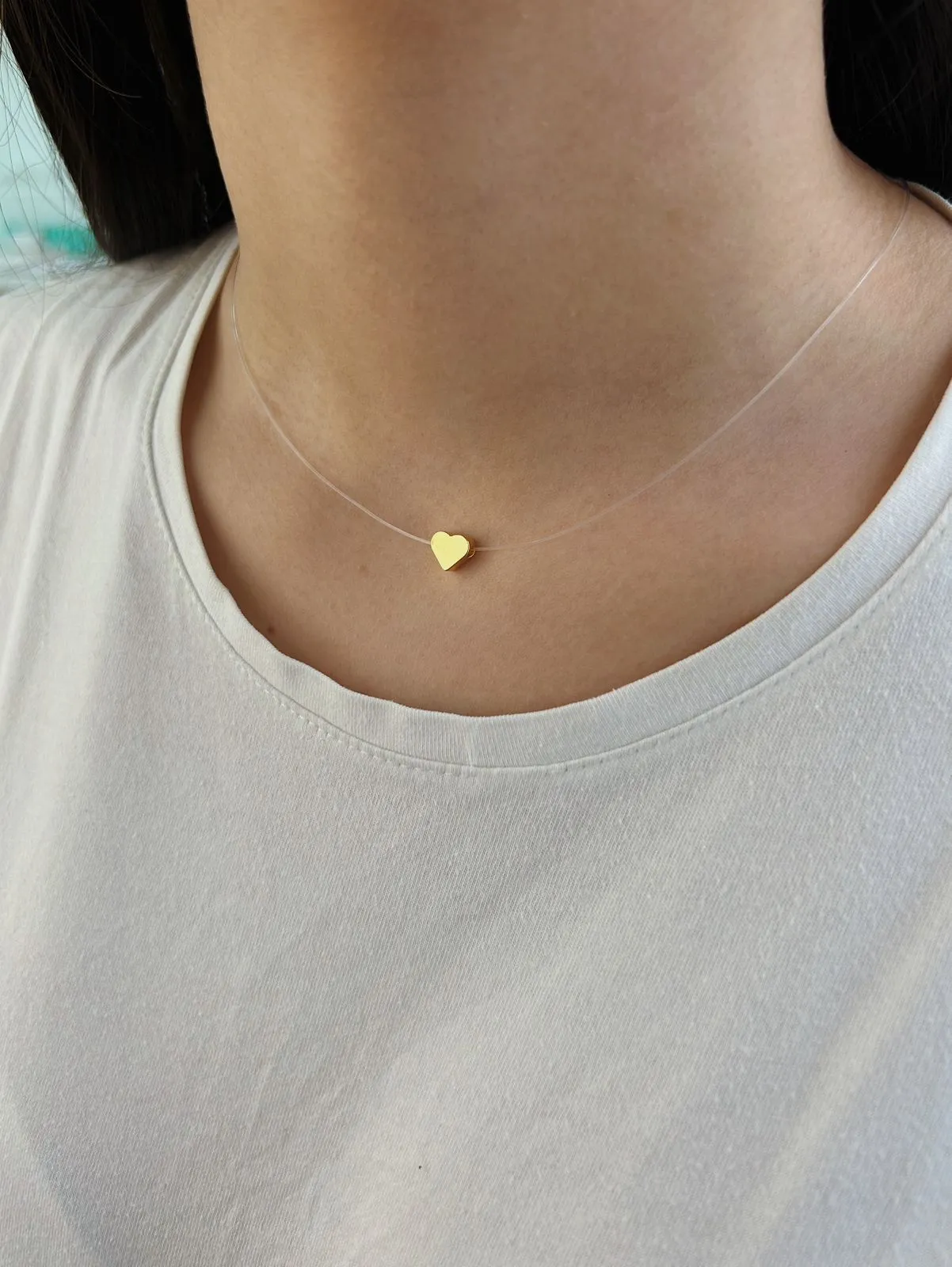 COLAR CORAÇÃO LISO COM FIO DE NYLON. 45CM DE COMPRIMENTO. BANHADO A OURO 18K.
