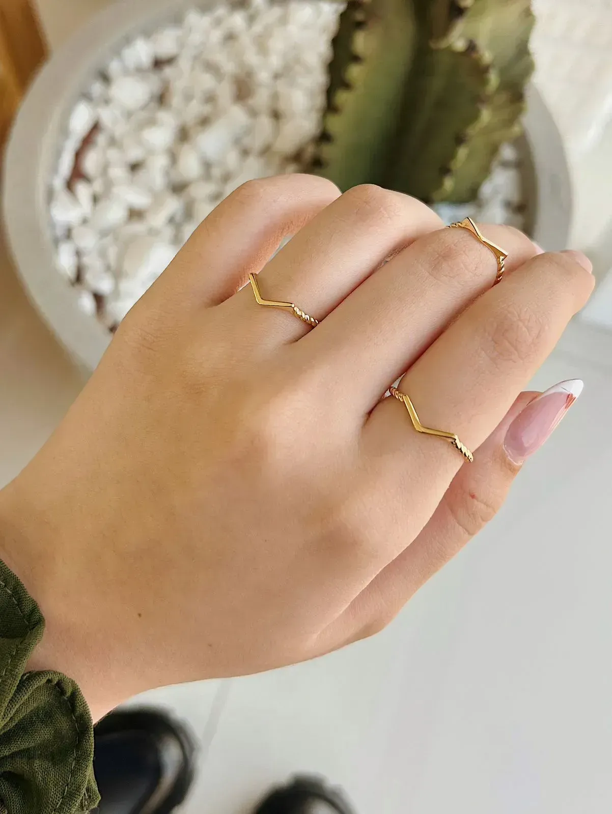 ANEL V COM MEIO ARO TORCIDO. BANHADO A OURO 18K.