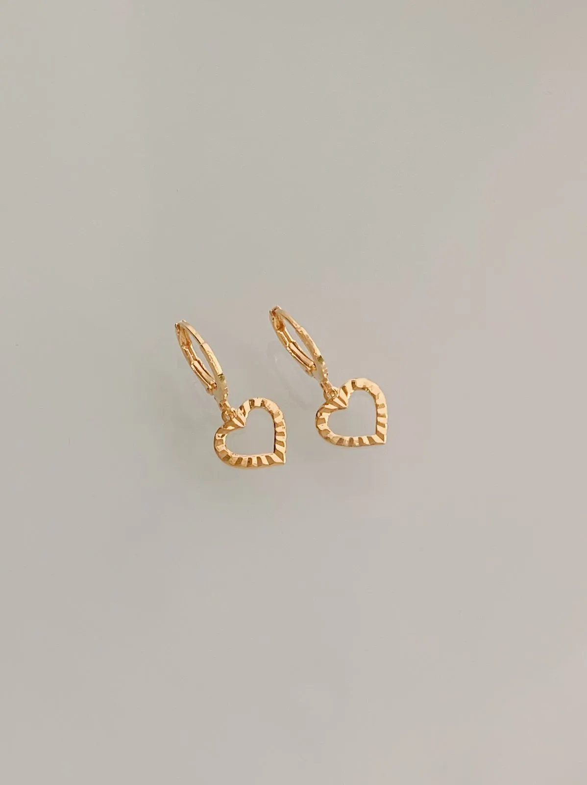 BRINCO ARGOLA COM PINGENTE DE CORAÇÃO VAZADO DIAMANTADO. BANHADO A OURO 18K.
