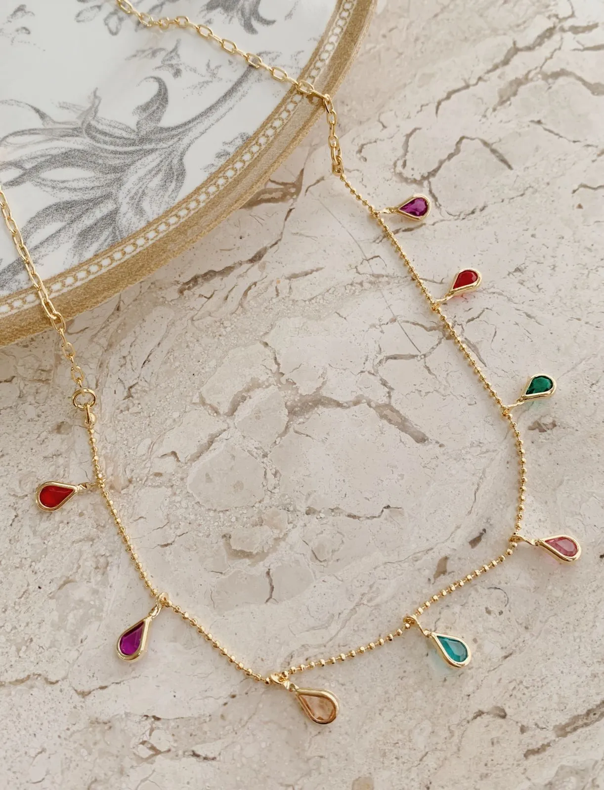 CHOKER COM GOTAS COLORIDAS. 35CM DE COMPRIMENTO E 5CM DE REGULAGEM. BANHADA A OURO 18K.