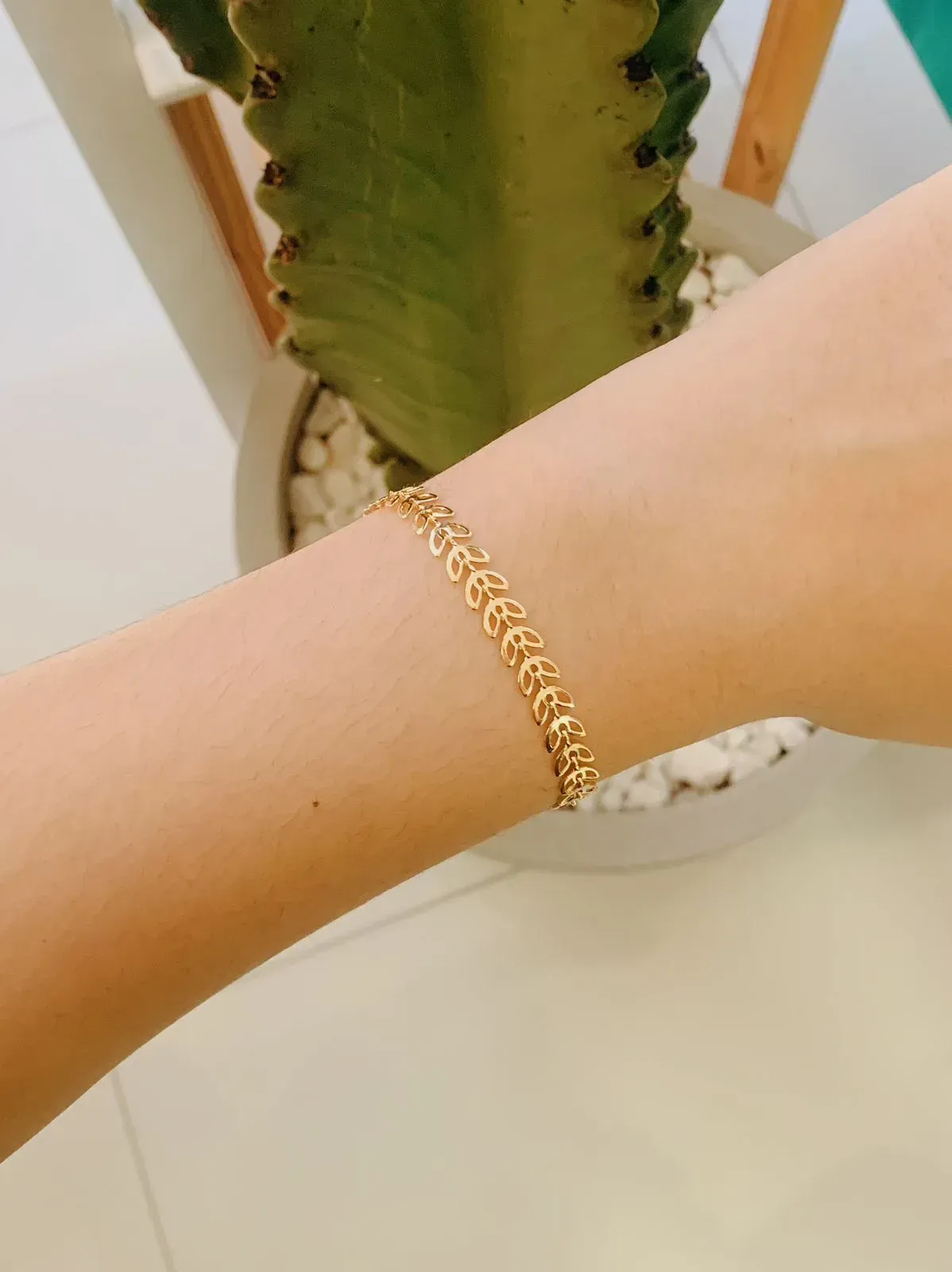 PULSEIRA FOLHINHAS VAZADAS.16CM DE COMPRIMENTO E 5CM DE REGULAGEM. BANHADA A OURO 18K.