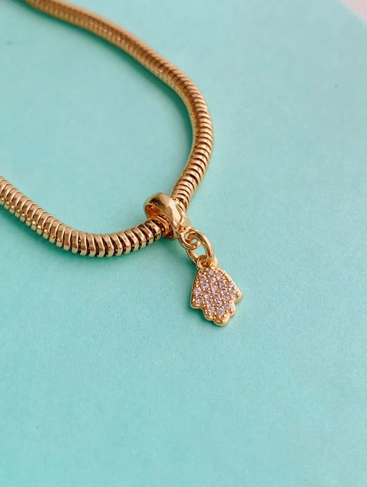 BERLOQUE MÃO DE FÁTIMA CRAVEJADA. BANHADO A OURO 18K.
