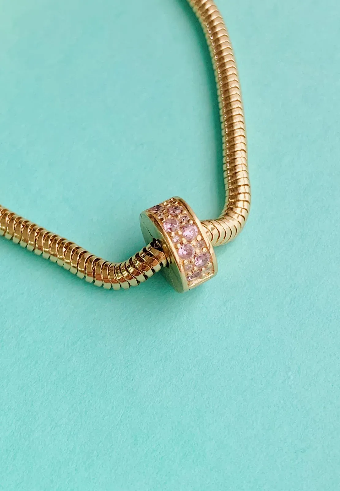 BERLOQUE TRAVA CRAVEJADA ROSA. BANHADO A OURO 18K.