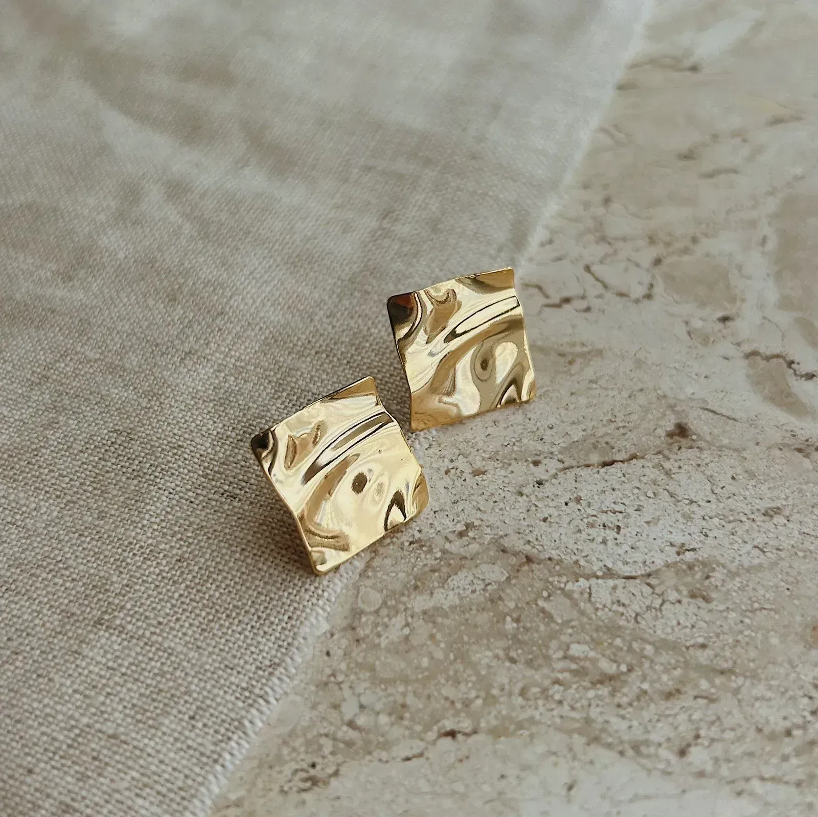 BRINCO QUADRADO MARTELADO. BANHADO A OURO 18K.