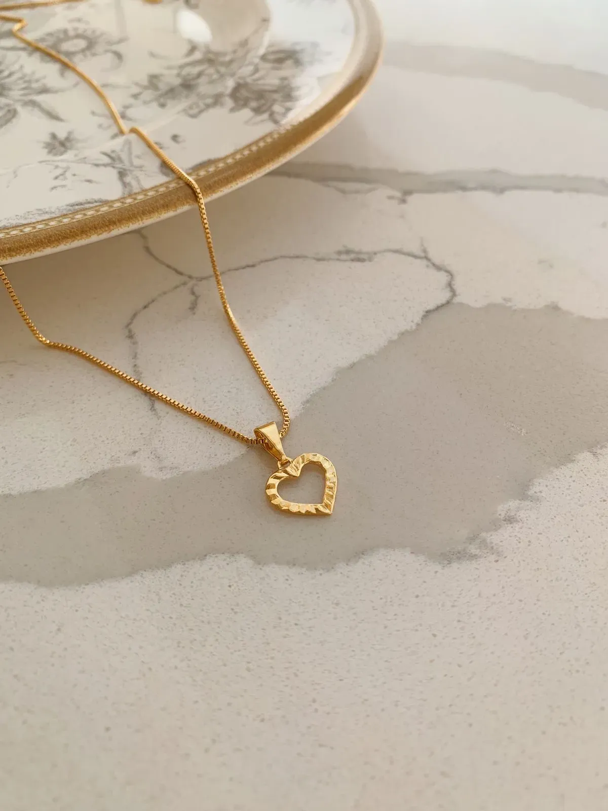COLAR COM PINGENTE DE CORAÇÃO VAZADO DIAMANTADO. 45CM DE COMPRIMENTO E 5CM DE REGULAGEM. BANHADO A OURO 18K.