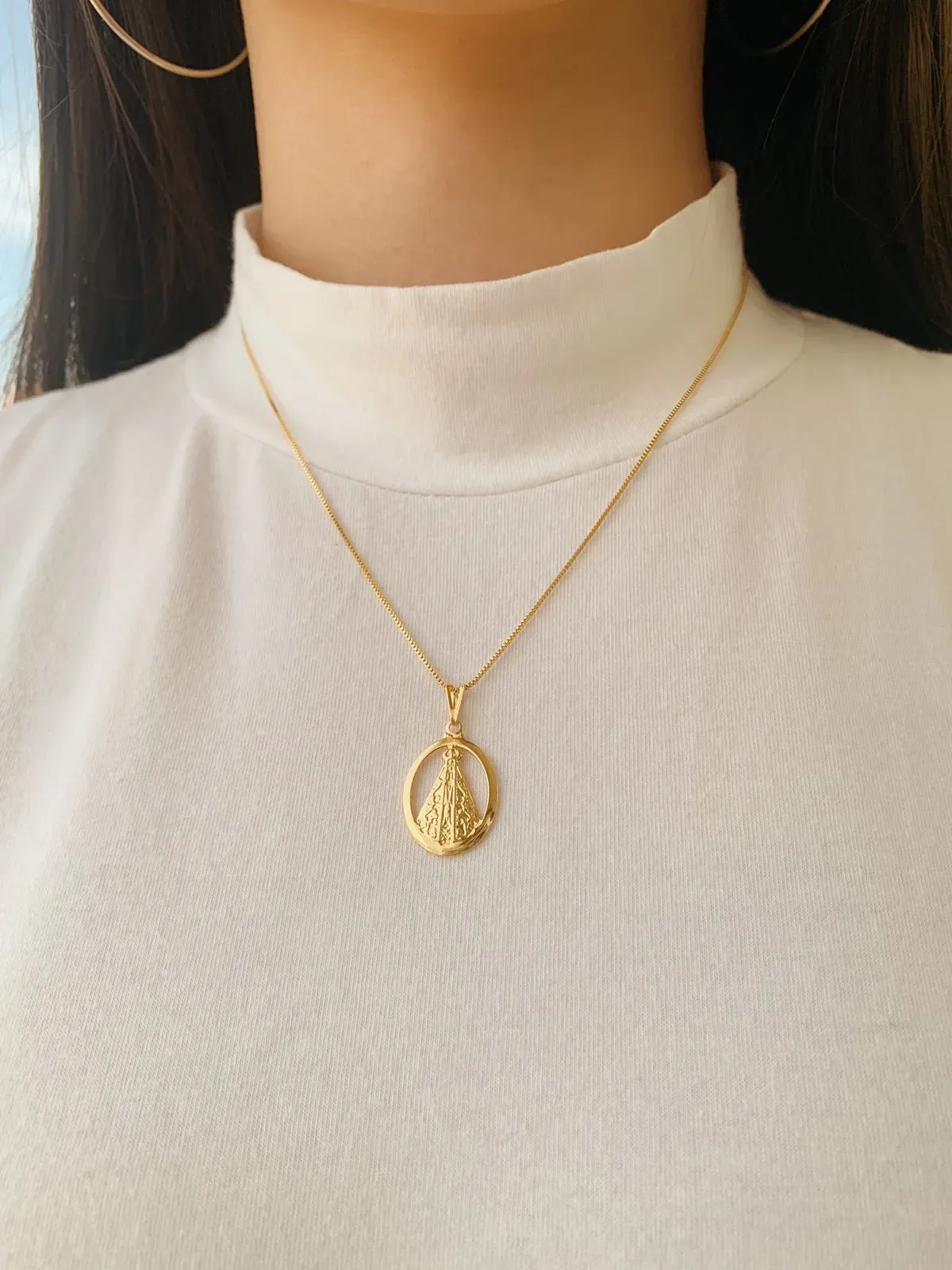 COLAR NOSSA SENHORA COM MEDALHA OVAL VAZADA. 45CM DE COMPRIMENTO E 5CM DE REGULAGEM. BANHADO A OURO 18K.