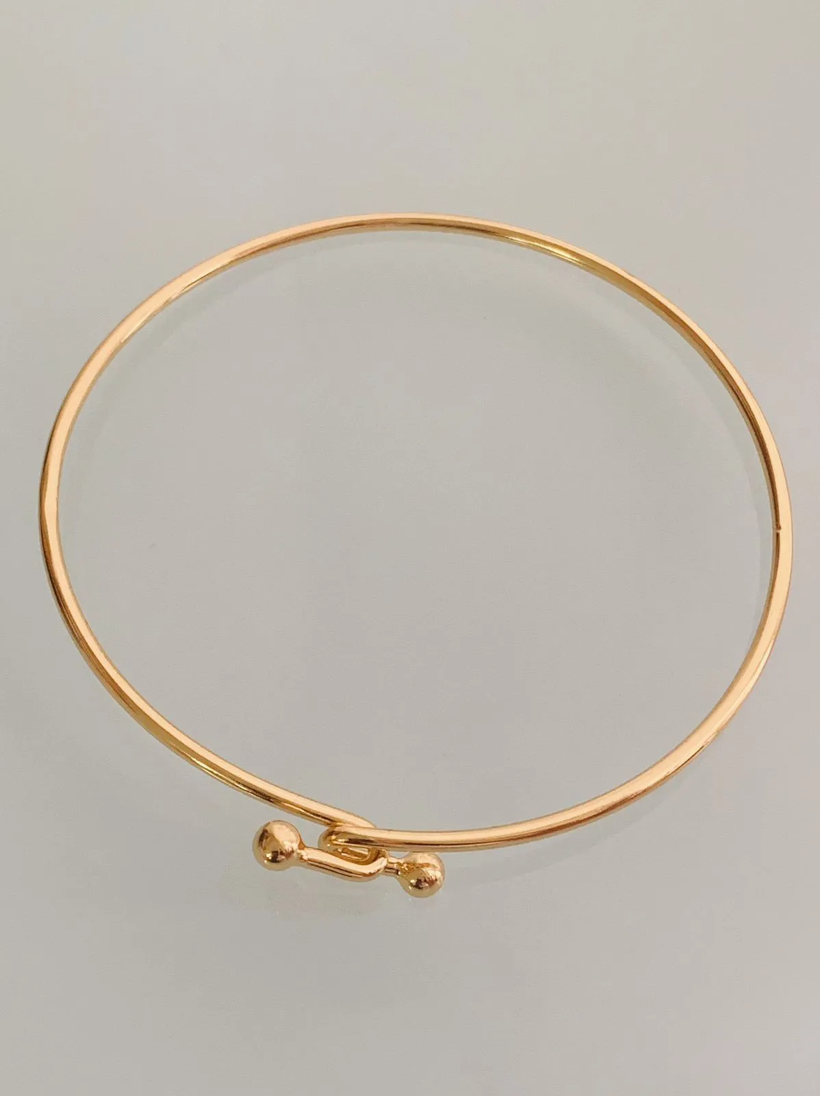 PULSEIRA BRACELETE LISO COM FECHO DE ENCAIXE. 6CM DE DIÂMETRO. BANHADA AOURO 18K.