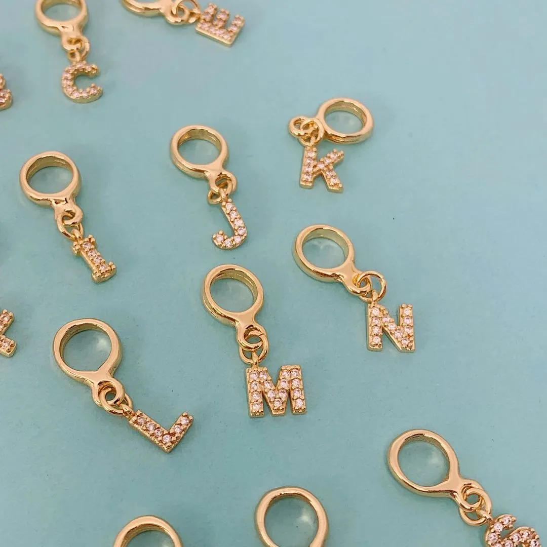 BERLOQUE DE LETRA G CRAVEJADO. BANHADO A OURO 18K.