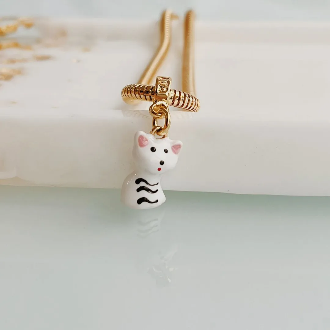 BERLOQUE GATO BRANCO. BANHADO A OURO 18K.