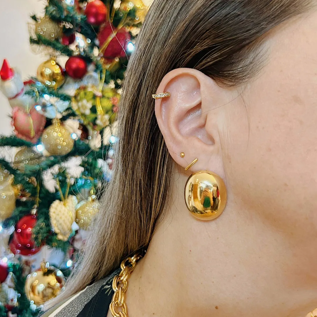 BRINCO MEIA ESFERA OVAL LISO. BANHADO A OURO 18K.