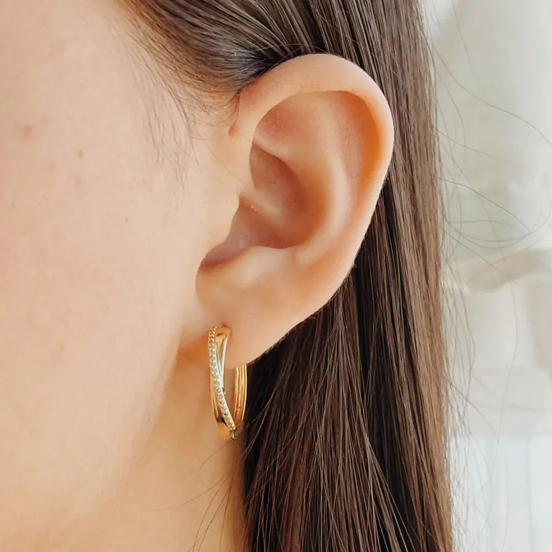 BRINCO ARGOLA COM FIO CRUZADO CRAVEJADO. FECHO CLICK. BANHADO A OURO 18K.