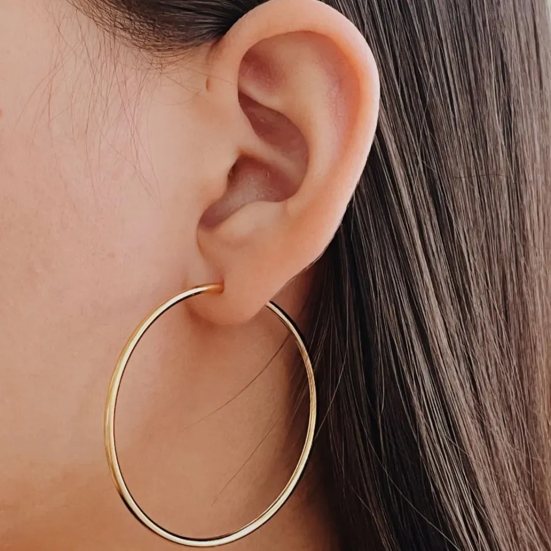 BRINCO ARGOLA TUBO LISA FINA. 4,5CM DE DIÂMETRO. FECHO ENCAIXE. BANHADO A OURO 18K.