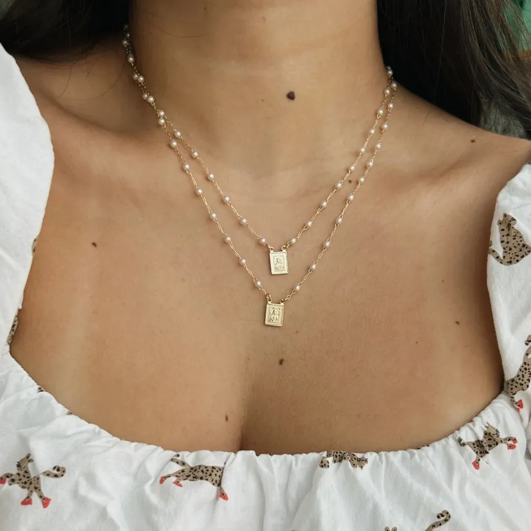 COLAR ESCAPULÁRIO DUPLO COM PÉROLAS. 45CM DE COMPRIMENTO E 5CM DE REGULAGEM. BANHADO A OURO 18K.