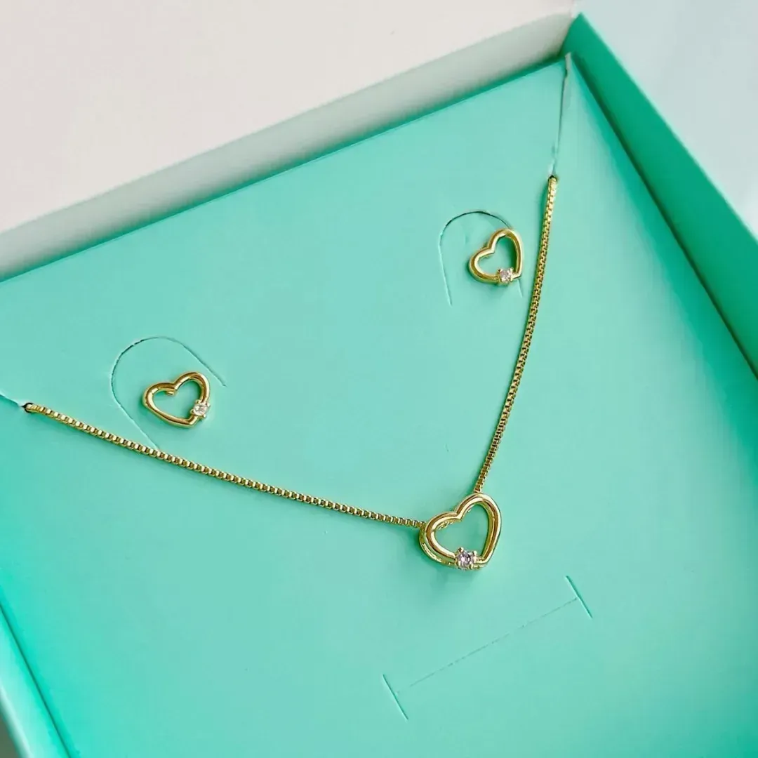 CONJUNTO CORAÇÃO COM PONTO DE LUZ CRISTAL. 45CM DE COMPRIMENTO. BANHADO A OURO 18K.