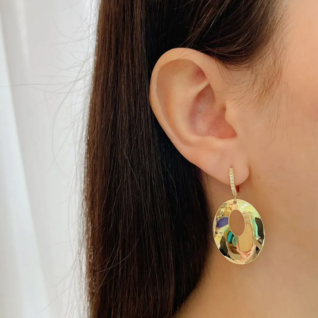 BRINCO ARGOLA CRAVEJADA COM PINGENTE CIRCULO VAZADO BANHADO A OURO 18K.